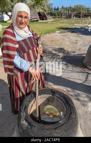 Sousse, Tunesien - 8 November 2019: Alte Dame Backen ein traditionelles arabisches Brot in Sousse in Tunesien Stockfoto