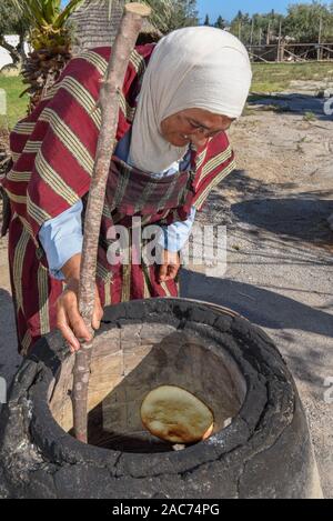 Sousse, Tunesien - 8 November 2019: Alte Dame Backen ein traditionelles arabisches Brot in Sousse in Tunesien Stockfoto