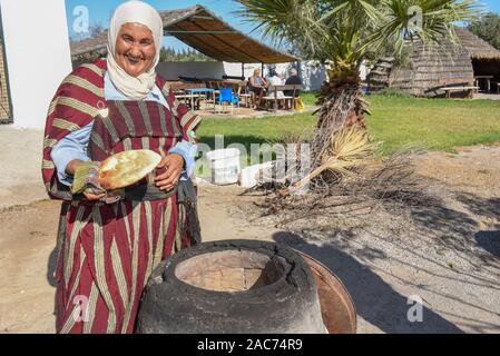 Sousse, Tunesien - 8 November 2019: Alte Dame Backen ein traditionelles arabisches Brot in Sousse in Tunesien Stockfoto