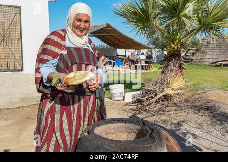 Sousse, Tunesien - 8 November 2019: Alte Dame Backen ein traditionelles arabisches Brot in Sousse in Tunesien Stockfoto