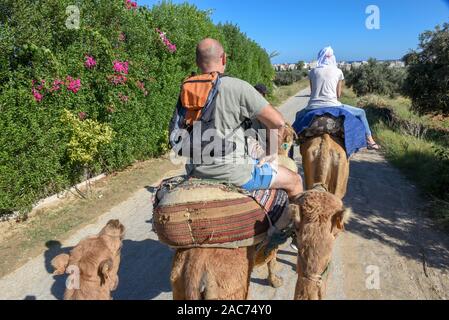 Sousse, Tunesien - 8 November 2019: Touristen auf einer Kamelkarawane in Sousse in Tunesien Stockfoto