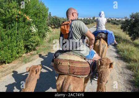 Sousse, Tunesien - 8 November 2019: Touristen auf einer Kamelkarawane in Sousse in Tunesien Stockfoto