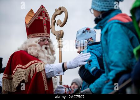 Krefeld, Deutschland. 01 Dez, 2019. Santa Claus begrüßt die wartenden Kinder. Der Sinterklaas (Nicholas) von Venlo kommt mit mehreren "Zwarten Piets" (Schwarzer Peter) im Zuge am Steiger in Krefeld mit dem Boot. Traditionell wird der "Zwarten Piets" Süßigkeiten an die Kinder verteilen. In den Niederlanden, der schwarz lackierte Helfer des Sinterklaas sind heute umstritten. Vor ein paar Tagen gab es Proteste mit mehreren Verhaftungen in Apeldoorn. Credit: Fabian Strauch/dpa/Alamy leben Nachrichten Stockfoto