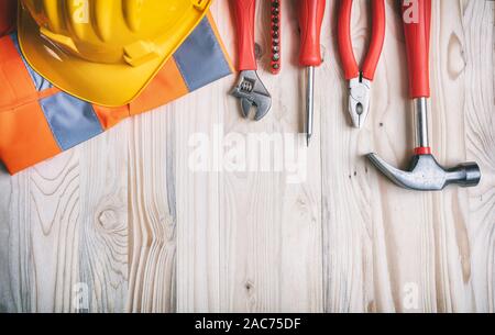 Bau, Renovierung Konzept. Handwerkzeuge und gelbe Farbe harten Hut auf Holz Hintergrund, Kopieren, Ansicht von oben. Stockfoto