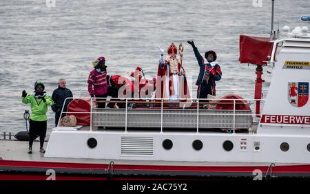 Krefeld, Deutschland. 01 Dez, 2019. Der Sinterklaas (Nicholas) von Venlo kommt mit mehreren "Zwarten Piets" (Schwarzer Peter) im Zuge am Steiger in Krefeld mit dem Boot. Traditionell wird der "Zwarten Piets" Süßigkeiten an die Kinder verteilen. In den Niederlanden, der schwarz lackierte Helfer des Sinterklaas sind heute umstritten. Vor ein paar Tagen gab es Proteste mit mehreren Verhaftungen in Apeldoorn. Credit: Fabian Strauch/dpa/Alamy leben Nachrichten Stockfoto