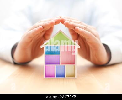 Wooden House von Händen geschützt Stockfoto