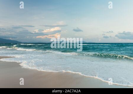 Schöne, leere tropischen weißen Sandstrand, kleine Wellen im Meer Hintergrund. Skyline mit blauem Himmel und weißen Wolken, Asien Stockfoto