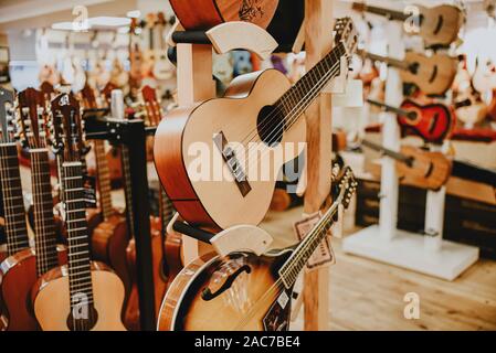 Vielen bunten hölzernen Gitarren auf Gitarrenständer in Store Showroom. Hintergrund Guitar Shop und Musik Shop. Stockfoto