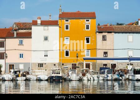 Bunte Fassaden am Hafen in der Altstadt von Cres leuchten in der Sonne und im Wasser spiegelt, Kvarner Bucht, Kroatien Stockfoto