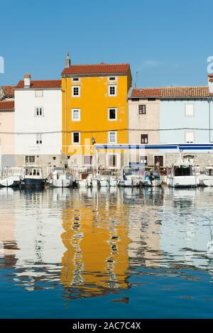 Bunte Fassaden am Hafen in der Altstadt von Cres leuchten in der Sonne und im Wasser spiegelt, Kvarner Bucht, Kroatien Stockfoto