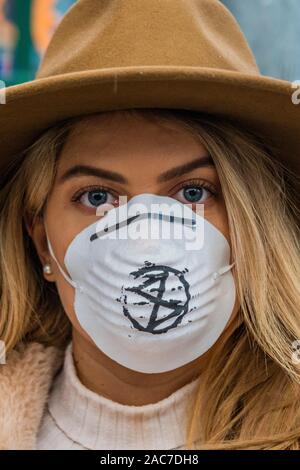 London, Großbritannien. 1. Dez 2019. Aussterben Rebellion Theatrics bringen Theater (zeigt, wie man in der Zukunft zu atmen saubere Luft atmen können Hubs bezahlen) und Krise Carollers zu Tottenham Court Road, bevor Sie marschieren die Oxford Street in Verschmutzung Masken. Beginn der Ausrottung Rebellion 12 Tagen der Krise das Klima und Ökologische Not ist ganz oben auf der Tagesordnung dieser Wahlen zu gewährleisten. Credit: Guy Bell/Alamy leben Nachrichten Stockfoto