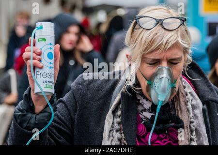 London, Großbritannien. 1. Dez 2019. Aussterben Rebellion Theatrics bringen Theater (zeigt, wie man in der Zukunft zu atmen saubere Luft atmen können Hubs bezahlen) und Krise Carollers zu Tottenham Court Road, bevor Sie marschieren die Oxford Street in Verschmutzung Masken. Beginn der Ausrottung Rebellion 12 Tagen der Krise das Klima und Ökologische Not ist ganz oben auf der Tagesordnung dieser Wahlen zu gewährleisten. Credit: Guy Bell/Alamy leben Nachrichten Stockfoto