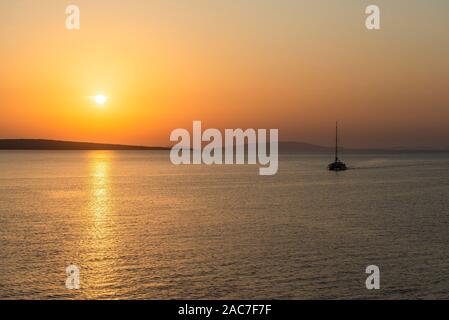 Segelyacht Segel auf dem ruhigen Meer zwischen den Inseln des Zadar Archipels vor der untergehenden Sonne, Kroatien Stockfoto