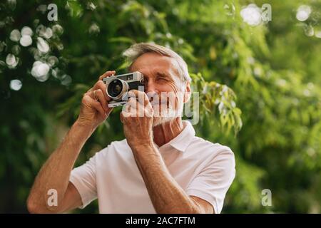 Ältere Menschen beim Fotografieren auf Film Kamera beim Gehen im Freien Stockfoto