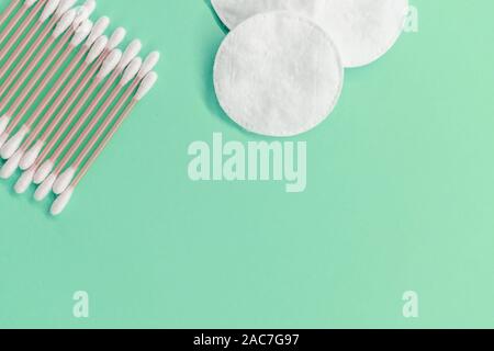 Wattestäbchen und Auflagen auf einer Münze Hintergrund. Umweltfreundlich. Konzept Kosmetik Stockfoto