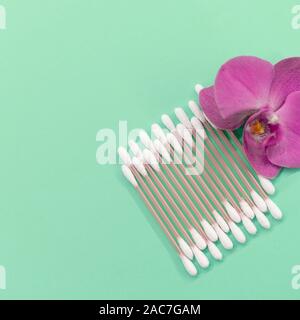 Wattestäbchen, Auflagen auf einer Münze Hintergrund. Orchid Flower. Umweltfreundlich. Konzept Kosmetik Stockfoto