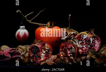 Herbst Früchte mit Weihnachten Kugeln auf schwarzem Hintergrund Stockfoto