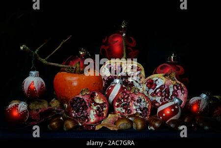 Herbst Früchte mit Weihnachten Kugeln auf schwarzem Hintergrund Stockfoto