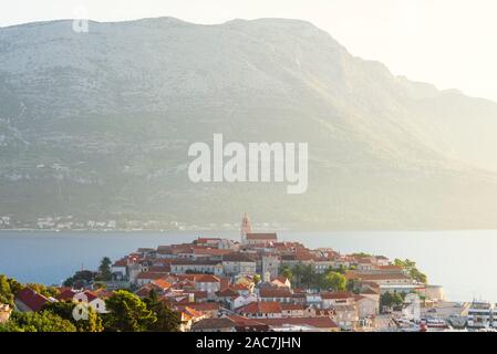 Die mittelalterliche Altstadt von Korcula vor der Sv. Ilija auf der Halbinsel Pelješac Gegenlicht der Sonne, Insel Korcula, Kroatien Stockfoto