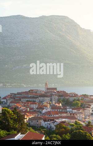 Die mittelalterliche Altstadt von Korcula vor der Sv. Ilija auf der Halbinsel Pelješac Gegenlicht der Sonne, Insel Korcula, Kroatien Stockfoto