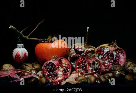 Herbst Früchte mit Weihnachten Kugeln auf schwarzem Hintergrund Stockfoto