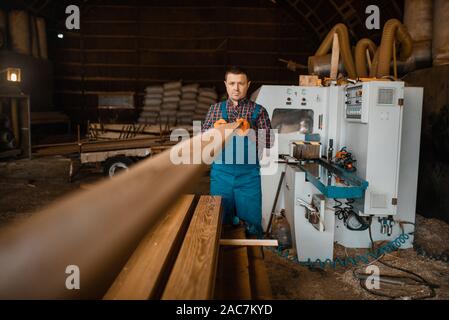 Zimmermann arbeitet auf holzbearbeitungsmaschine, Bauholz Stockfoto
