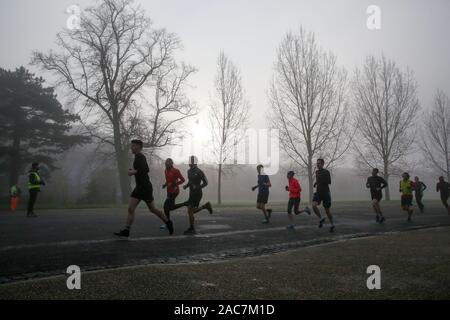 Athleten jog inmitten dichter Nebel in Finsbury Park, nördlich von London. Stockfoto