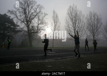 Athleten jog inmitten dichter Nebel in Finsbury Park, nördlich von London. Stockfoto