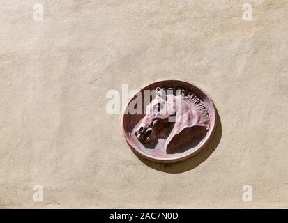 Pferdekopf aus Stein an der Gebäudewand in Montopoli in Val d'Arno, Toskana, Italien. Stockfoto