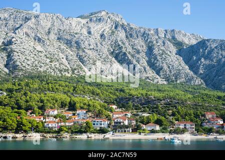 Häuser der Stadt Orebic auf der Sandstrand vor den grünen Hängen und Karst Felswände der Sveti Ilija massiv, Peljesac, Kroatien Stockfoto