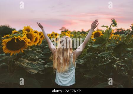 Frau glücklich erhobenen Händen in Sonnenblumen Feld Harmonie mit der Natur Reisen gesunder Lebensstil im Freien Ferien allein Stockfoto