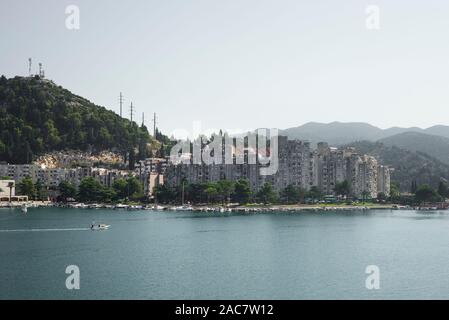 Beton Hochhaus am Hafen von Ploce vor bewaldeten Hügeln mit funkmasten an der kroatischen Adriaküste, Dalmatien, Kroatien, Europa Stockfoto