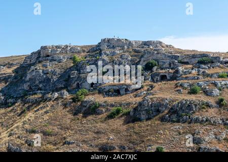 Frühe rock Höhlenwohnungen auf den Klippen von La Gravina di Matera, eine tiefe Schlucht um den Rand von Matera, Basilikata, Süditalien läuft Stockfoto