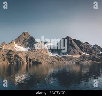 Arktische Landschaft im Sommer mit hohen Bergen und Eisberge auf dem Meer in Ofjords, Scoresby-sund, Ostgrönland. Foto in Grönland. Stockfoto