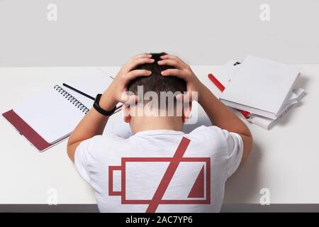 Gelangweilt und müde Junge Hausaufgaben auf weißem Schreibtisch in seinem Zimmer. Schüler Probleme Konzept. ISo Stockfoto