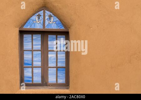 Alte Glasfenster auf der Außenseite eines Adobe Kirche Stockfoto