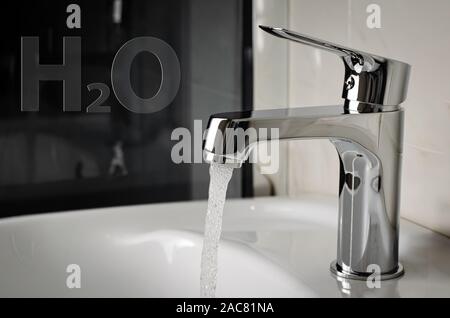Fließt das Wasser aus dem Wasserhahn oder der Wasserhahn im Bad. H2O geschrieben Stockfoto