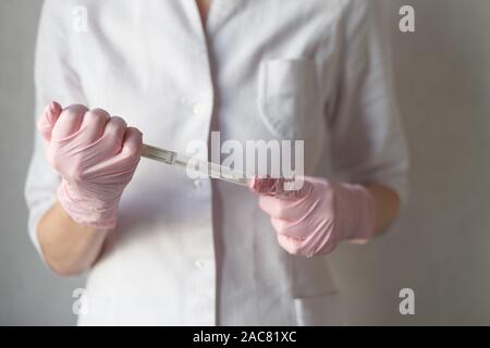 Eine behandschuhte Hand mit einem medizinischen Tupfer Rohr Stockfoto