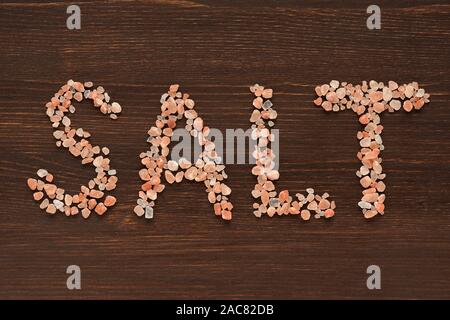 Wort Salz in rosa Hymalayan Salzkristalle auf hölzernen Hintergrund Stockfoto