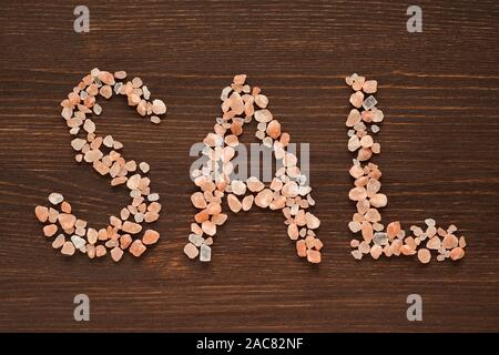 Wort Sal in rosa Hymalayan Salzkristalle auf hölzernen Hintergrund Stockfoto