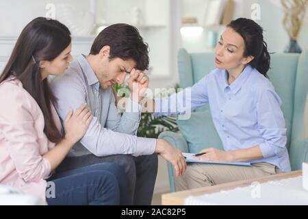 Psychologe und junge Frau umgekippt Mann während der Therapie unterstützen. Stockfoto