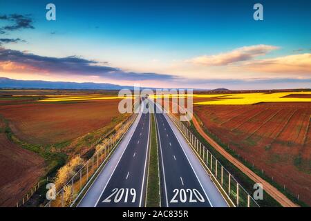 Luftaufnahme der Autobahn auf den Sonnenuntergang. Transport Hintergrund. Landschaft mit Road in der Nähe von grünen Feldern. Stockfoto