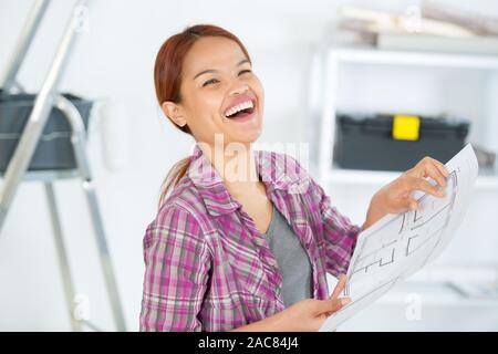 Jolly Frau an Raumplan suchen Stockfoto