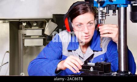 Professionelle Frau arbeiten mit einer elektrischen Bohrmaschine Stockfoto