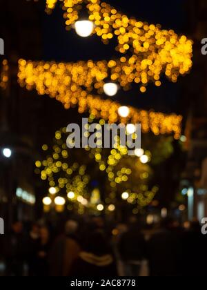 Defokussierten Menschen zu Fuß auf einer Straße mit Weihnachtsbeleuchtung - verschwommenen Hintergrund Stockfoto