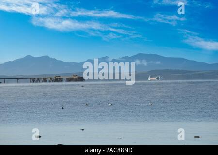 Einige der größeren Handelsschiffe und den Blick über das alte Kraftwerk Mole in Inverkip zu Arran in der Ferne wie die kalten Nebel steigt aus. Stockfoto