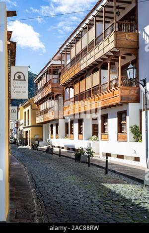 Typische Teneriffa Stil Gebäude mit kunstvoll verzierten hölzernen Balkonen mit Blick auf die gepflasterte Straße in Garachico, Teneriffa, Spanien am 23. November 2019 Stockfoto