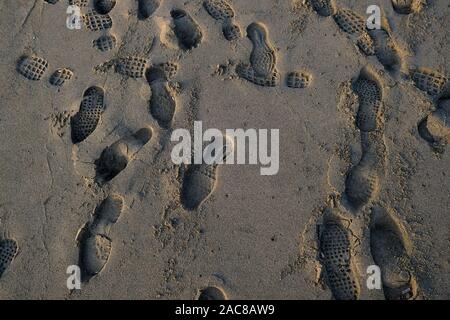 Menschliche schuhe Schritte Fußabdrücke auf wilden sandigen Strand, Textur wallpaper Stockfoto