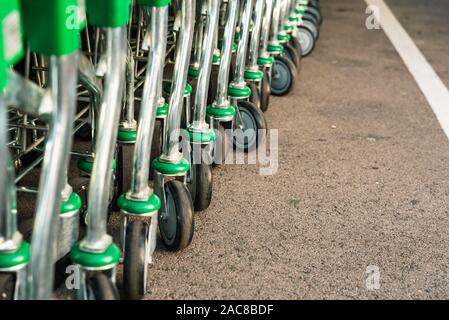 Valencia, Spanien - 3. Juli 2019: Detail der vielen grünen aus Metall und Kunststoff, Supermarkt Karren am Eingang eines Store gestapelt. Stockfoto