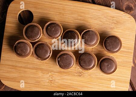 Menge ganz süßen braunen Toffee auf Bambus Schneidebrett flatlay auf braunem Holz Stockfoto